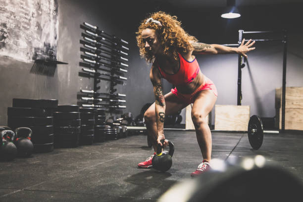 istock Red-haired girl with athletic physique during kettlebell workout 880565242