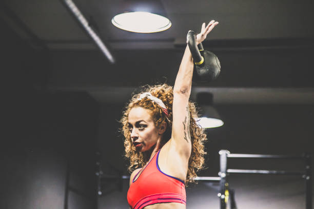 istock Red-haired girl with athletic physique during kettlebell workout 880565276