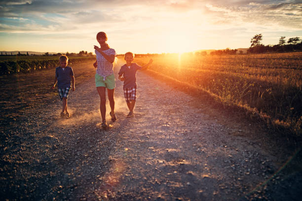 istock Three kids running on dirt road in Tuscany. 880565518