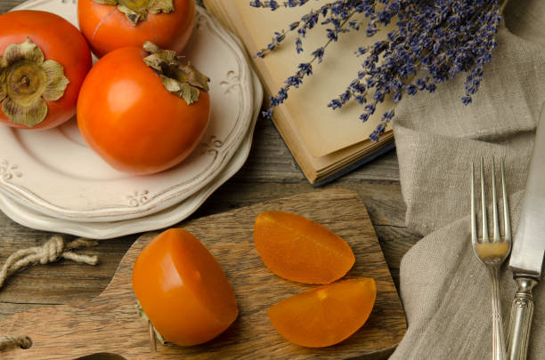 świeże persimmon. plastry świeżych owoców - lavender orange fruit table zdjęcia i obrazy z banku zdjęć