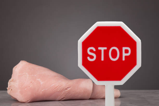 Do not eat meat A piece of boiled ham laying on a marble plate. In front a stop sign . dont eat meat stock pictures, royalty-free photos & images