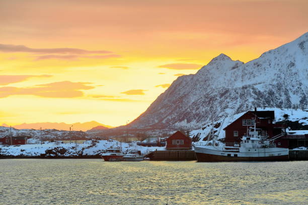 SE.-wards view-sunrise over Svolvaer fishing port-Litlmolla island in background. Lofoten-Nordland-Norway.0609 SE.-wards view from Lofoten Rorbuer suites in the NE.area of town-sunrise over Svolvaer fishing port-big maroon fishing ship moored at the dock-Litlmolla island in background. Lofoten-Nordland-Norway. harbor of svolvaer in winter lofoten islands norway stock pictures, royalty-free photos & images