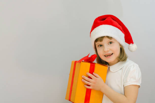 istock Christmas kid in Santa hat on white background received a gift. 880594166