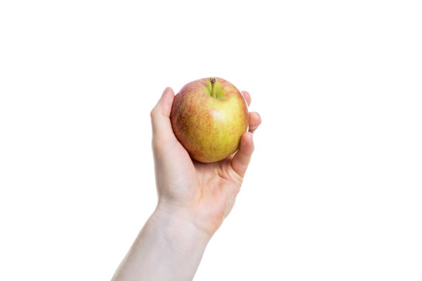 istock Holding an apple in the hand isolated on white background 880596284