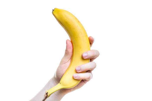 tenere una banana in mano isolata su sfondo bianco - men banana holding cut out foto e immagini stock