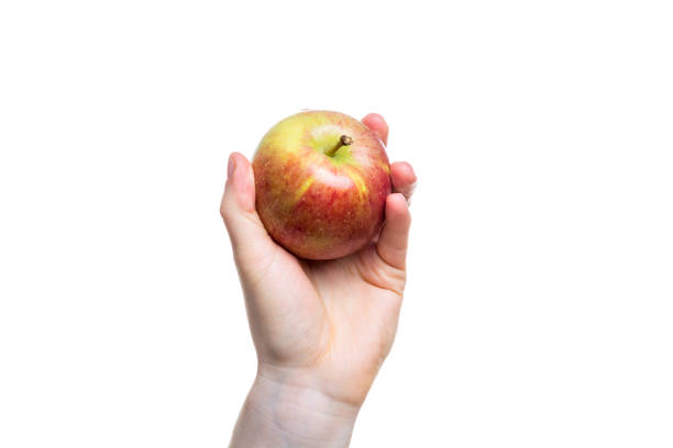 istock Holding an apple in the hand isolated on white background 880596534