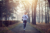 istock Young woman is running in the cold foggy morning 880610732