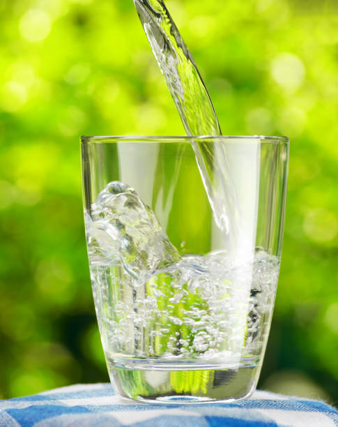 istock Glass of water on nature background 880628038