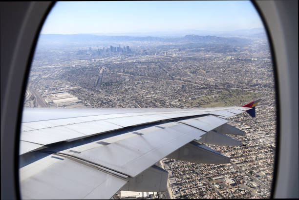 Aerial shot of downtown Los Angeles and Santa Monica mountain from a commercial airliner framed by the window