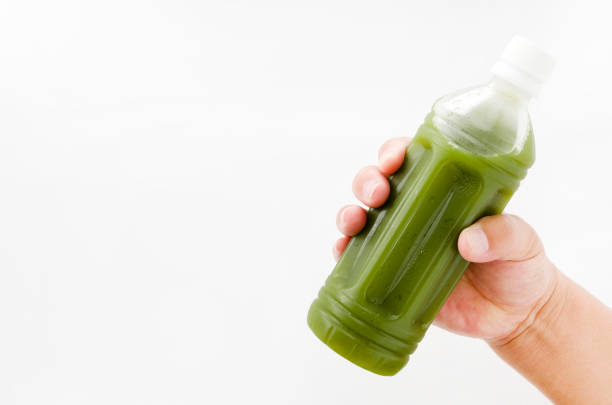 istock hand holding green juice  in bottle isolated on white background 880654028