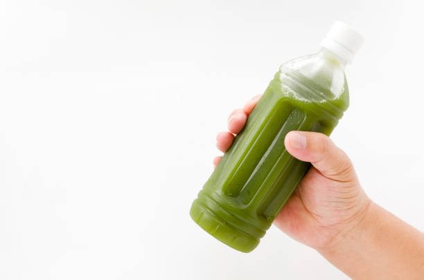 istock hand holding green juice  in bottle isolated on white background 880654078