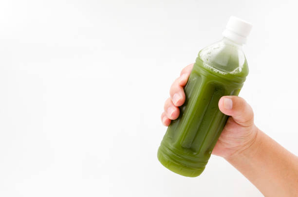 istock hand holding green juice  in bottle isolated on white background 880654112