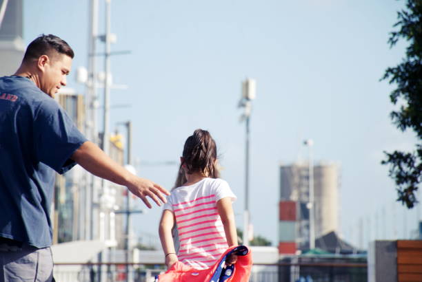 Unrecognizable daddy and daughter holding hands on a beautiful sunny day - Lifestyles