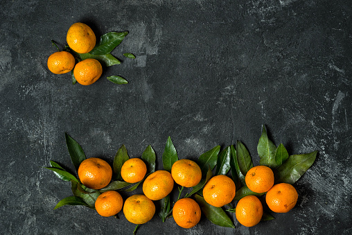 mandarines with leaves on a black cement background with copy space for your menu text