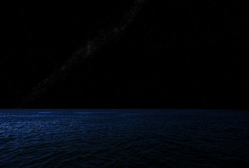 Night sky over shining ocean, nebula and lots of shiny stars with copy space.
