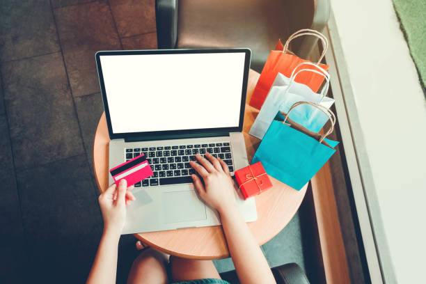 femme avec ordinateur portable, achats en ligne avec carte de débit au café - women holding shopping bag living room photos et images de collection