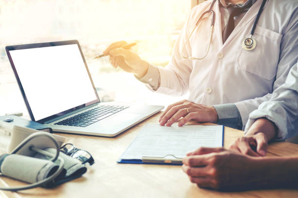 istock Doctor consulting with patient presenting results on blank Screen tablet computer sitting at table 880750644