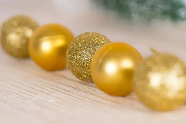 golden christmas baubles on white wooden table