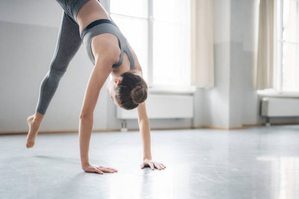 istock girl practicing gymnastics exercises on floor in studio 880761098