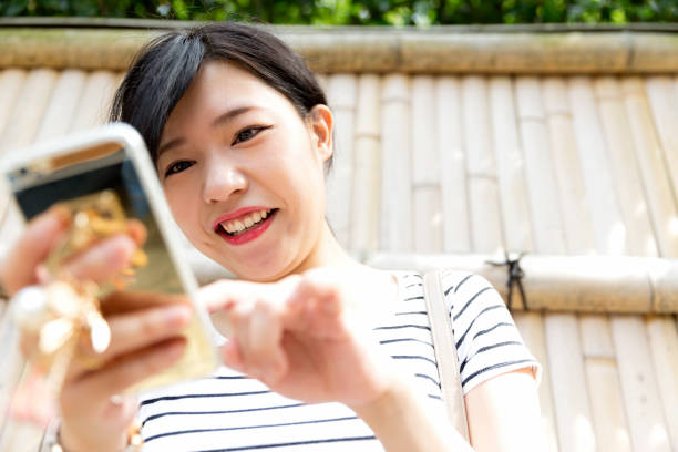 istock Low angle perspective of a Japanese woman using her smart phone 880807828
