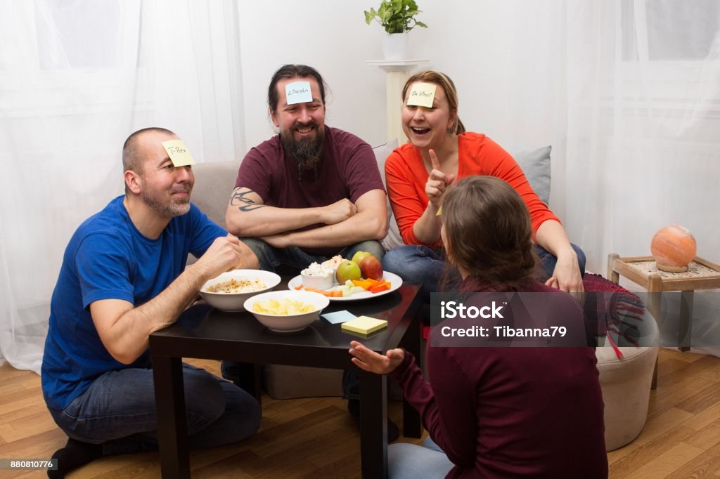 Funny guessing game Friends sitting together and playing a funny guessing game Leisure Games Stock Photo