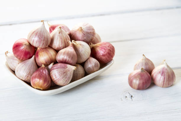 istock Fresh healthy garlic in ceramic bowl on white table 880815786