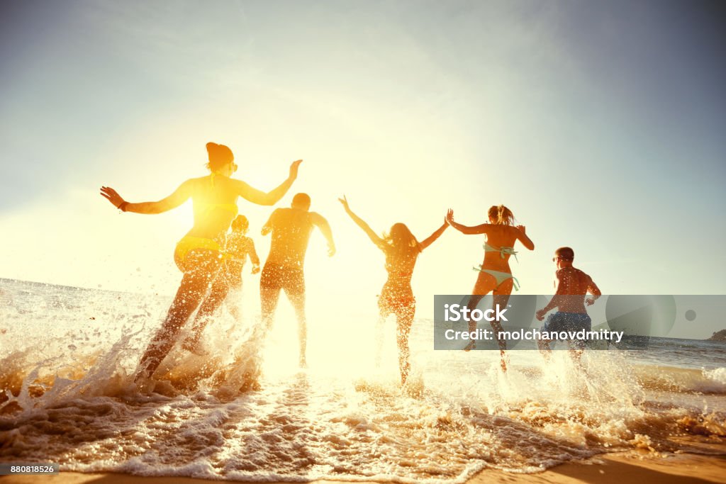 Grand groupe amis coucher de soleil mer plage exécute - Photo de Plage libre de droits