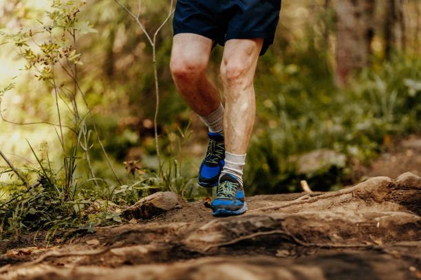 istock elderly man feet runner running rocks in forest marathon 880842192