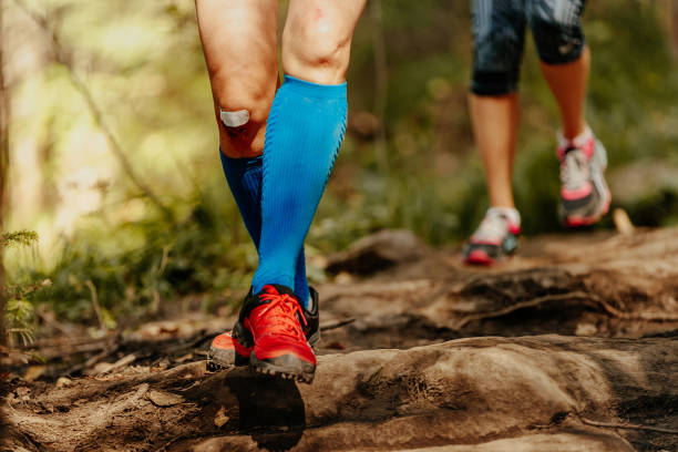 istock woman feet runner running rocks in blue compression socks 880842210