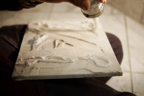 istock Tilers hands are installing a marble tile on a wall in a bathroom. 880847958