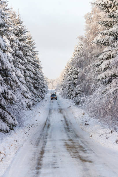 istock Slippery winter road with a car in the woods 880851048