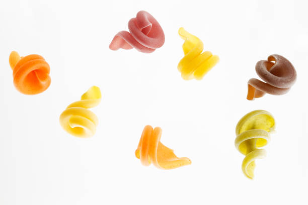 istock Multi-colored pasta isolated on white background flying in the air 880851404