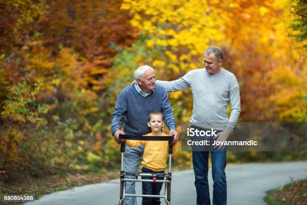 Elderly Father Adult Son And Grandson Out For A Walk In The Park Stock Photo - Download Image Now