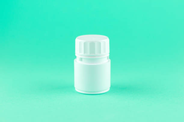 istock Close up white pill bottle on aquamarine background with copy space. Focus on foreground, soft bokeh. Pharmacy drugstore concept 880855068