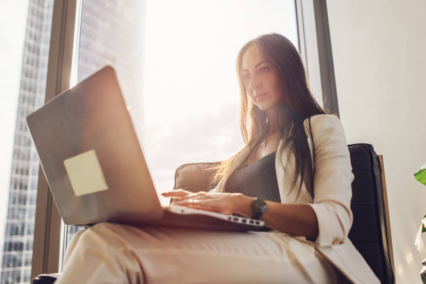 istock Young woman working on laptop sitting at home 880861868