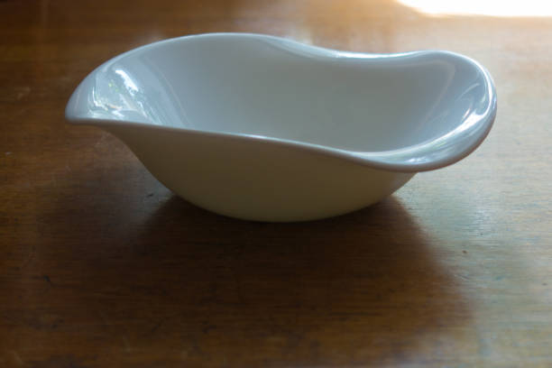 istock Non-symmetric empty ceramic bowl on wooden table 880864342