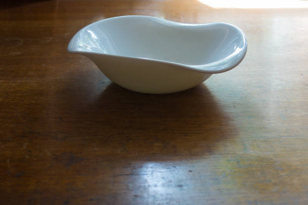 istock Rimmed white porcelain bowl on wooden table 880864368