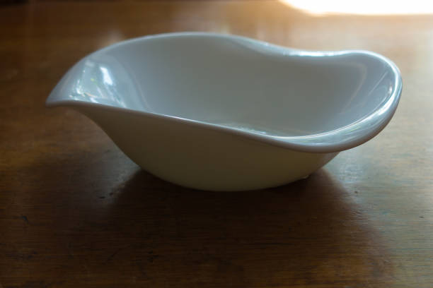 Sauceboat with wavy rim on wooden table