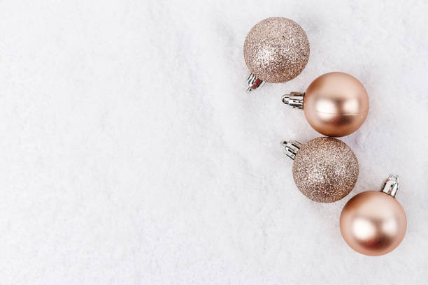 istock Top view of arranged Christmas decorative baubles lying on white snow. 880905264