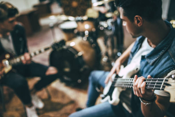 Repetition of rock music band. Repetition of rock music band. Bass guitar player, electro guitar player and drummer behind the drum set. Rehearsal base performance group stock pictures, royalty-free photos & images