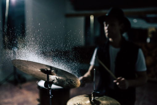 Repetition of rock music band. Drummer behind the drum set. Water splashes on cymbal.
