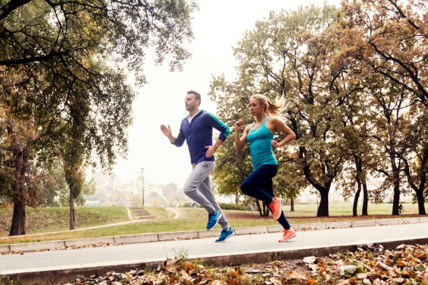istock Jogging couple - young man and woman competing 880908464