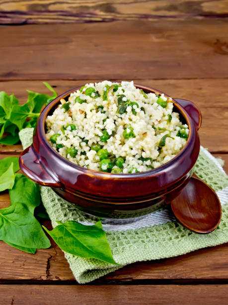 istock Couscous with spinach in bowl on wooden board 880911200