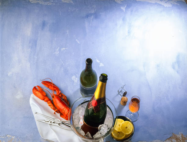 Lobster with champagne on ice and  lemon on a blue background, high angle view