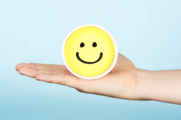 istock Hand giving hapiness concept. Yellow happy face emoticon. 880914986