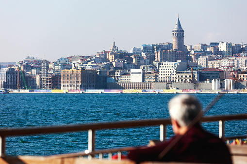 Istanbul, Turkey- November 24, 2017: Ferry crossing the Bosporus with the Galata Tower in background. Karakoy district.