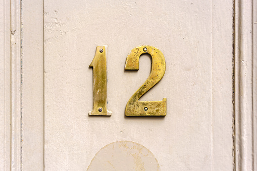 Gold colored house number twelve (12)