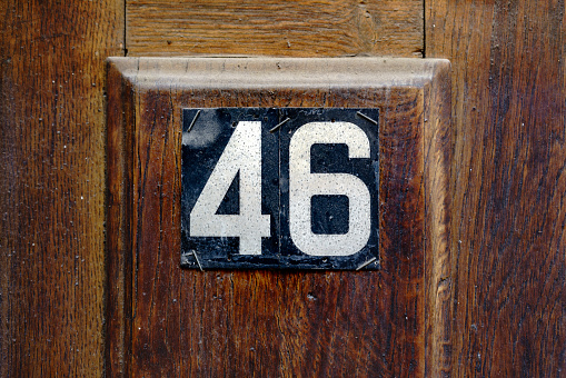 Weathered grunge square metal enameled plate of number of street address with number 51 isolated on white background