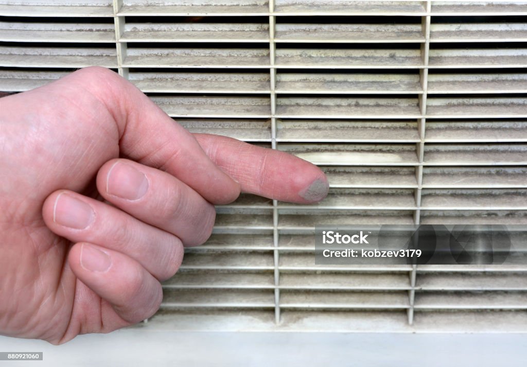 Person checks the contamination of the ventilation grille Person checks the contamination of the ventilation grill by swiping a finger along it Air Duct Stock Photo