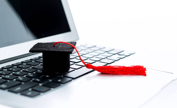 sombrero de graduación en el teclado de la computadora - online degree fotografías e imágenes de stock